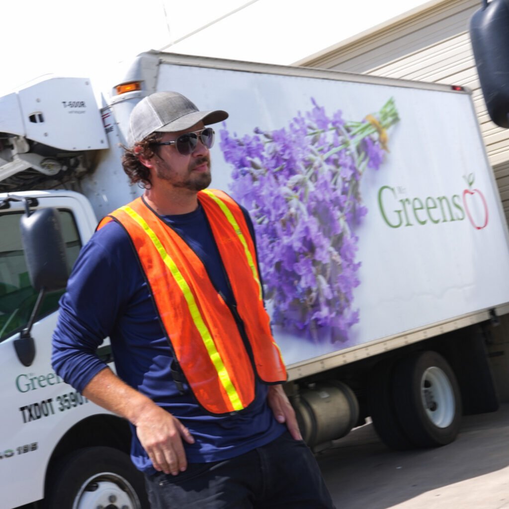 A Mr Greens team member beside a branded delivery truck
