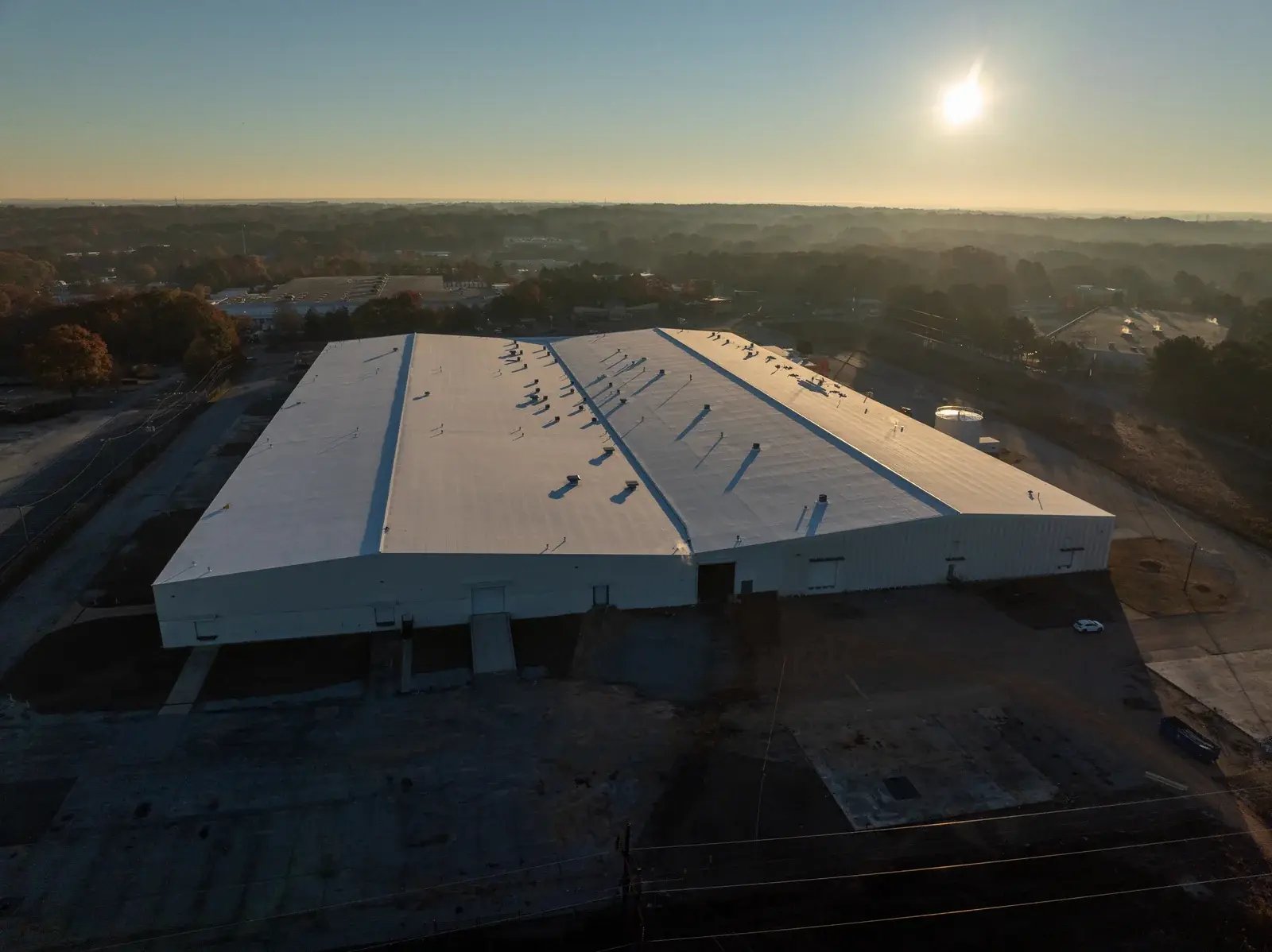 Aerial view of a large commercial roof in low evening light.