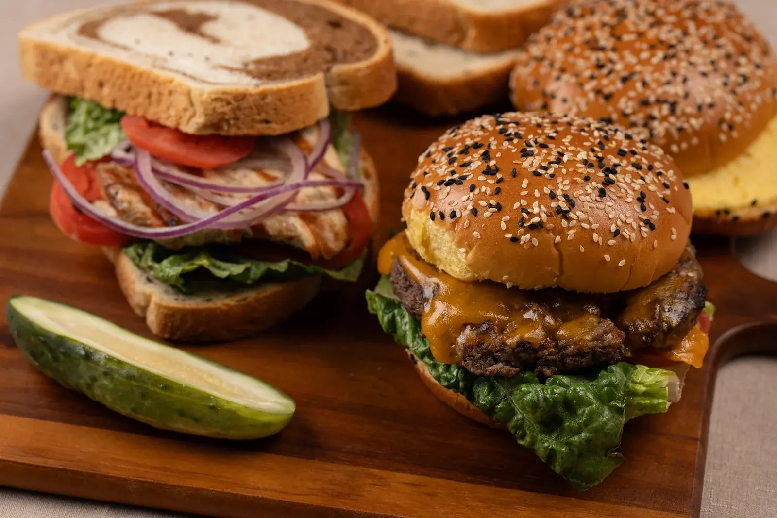 A sandwich and burger made with Engelman’s bread, served with a pickle.