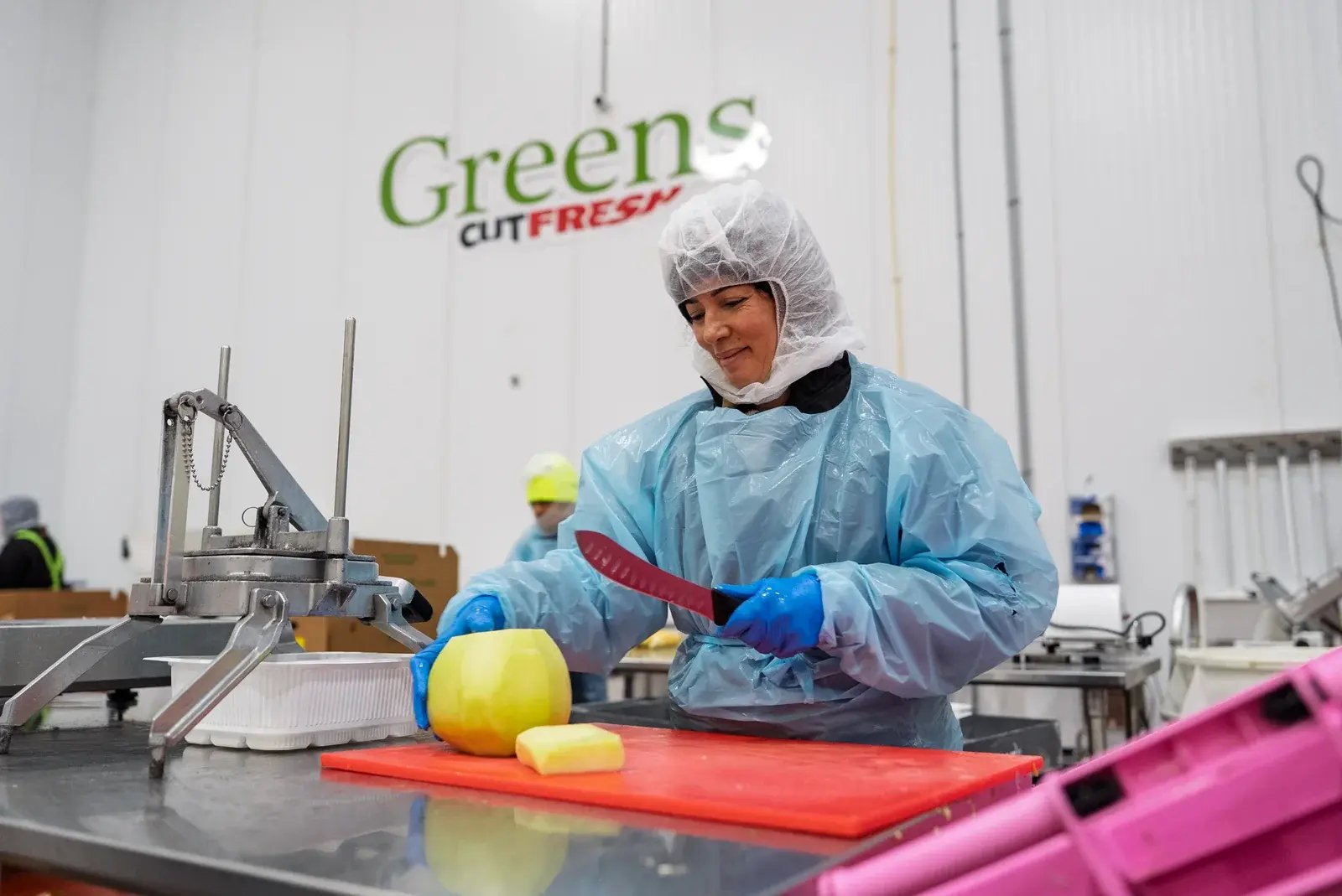 A Mr Greens staff member preparing a melon in the Cut Fresh production area.