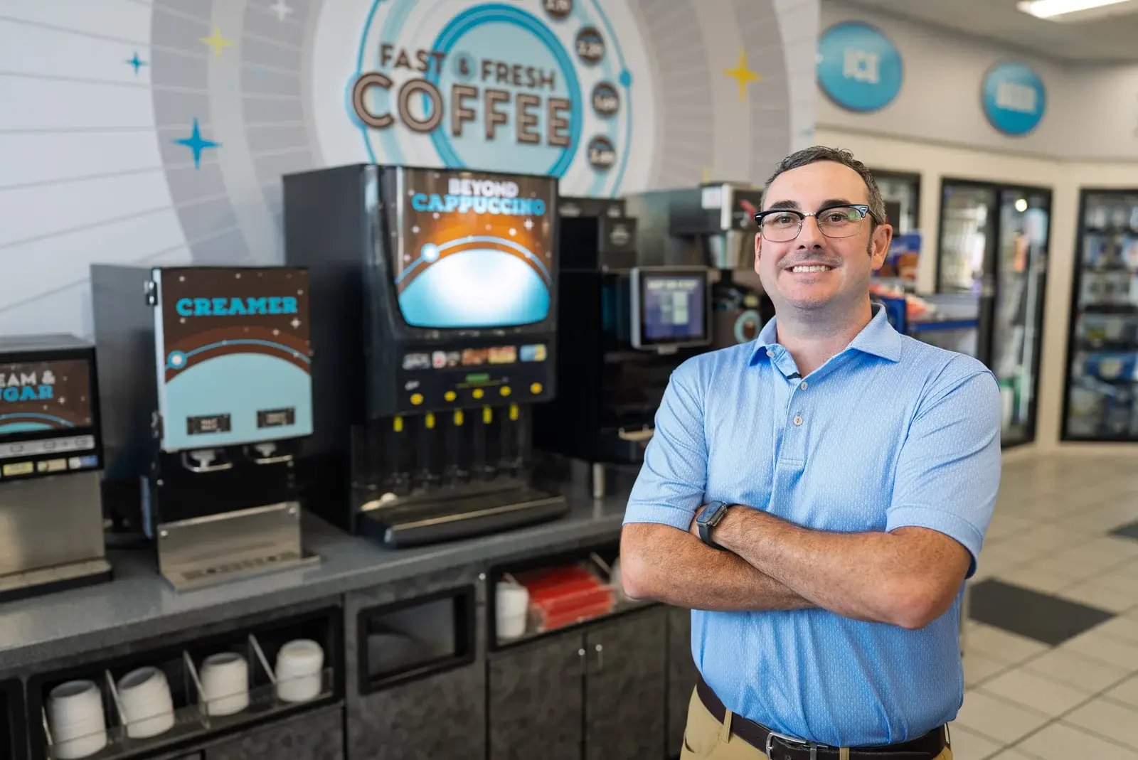 A Ronnoco staff member standing beside coffee machines.